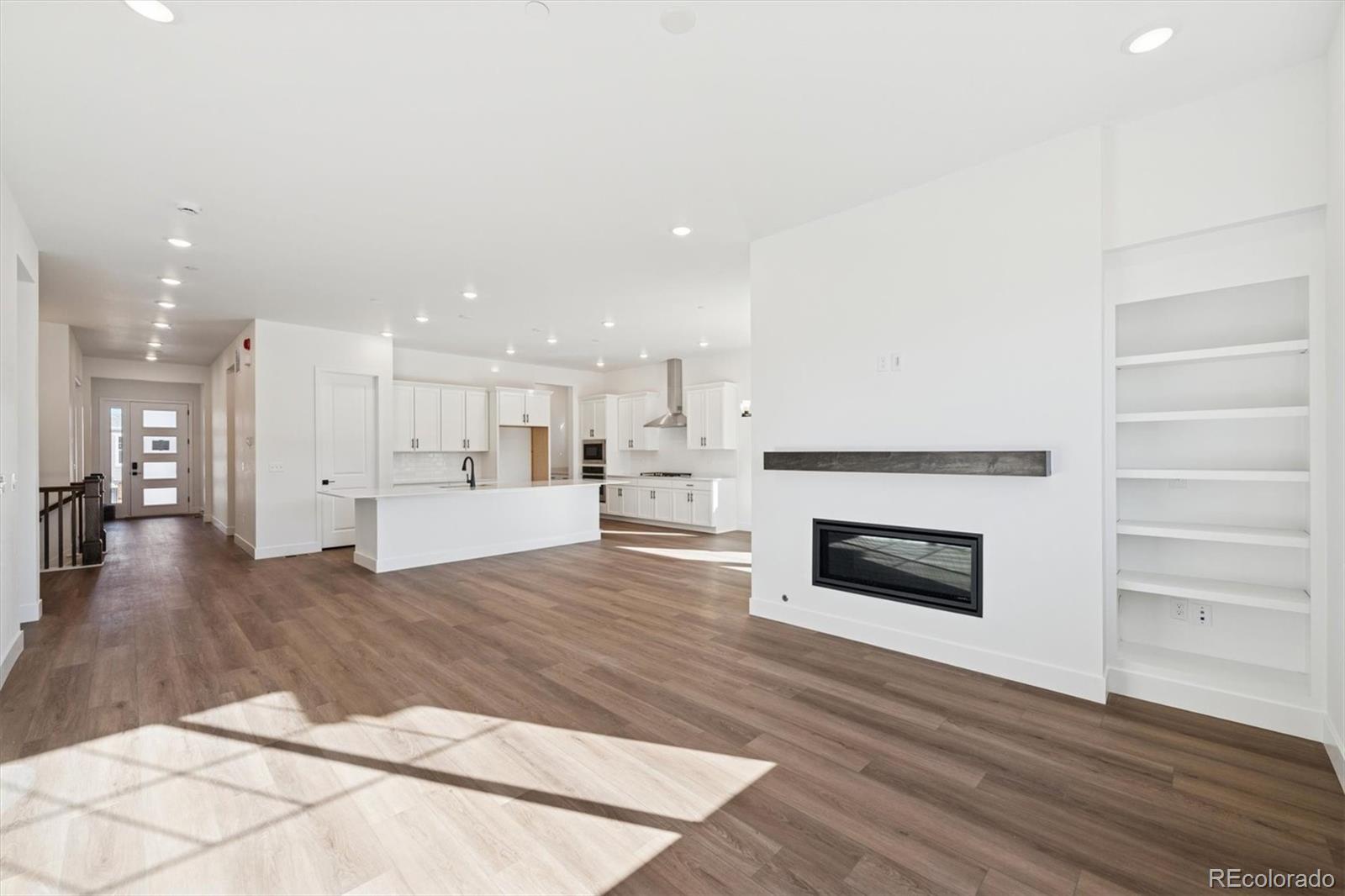 1242 Summit Rise Drive Erie, CO 80516 - Photo 11 of 25 a view of kitchen living room with wooden floor and fireplace