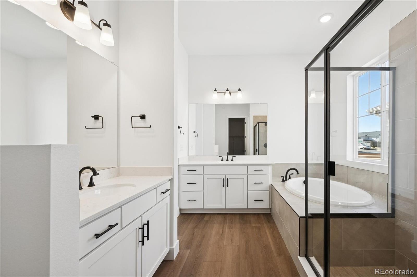 1242 Summit Rise Drive Erie, CO 80516 - Photo 18 of 25 a spacious bathroom with a double vanity sink a mirror and a bathtub