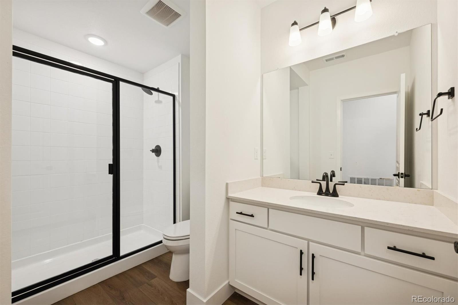 1242 Summit Rise Drive Erie, CO 80516 - Photo 22 of 25 a bathroom with a double vanity sink mirror and shower