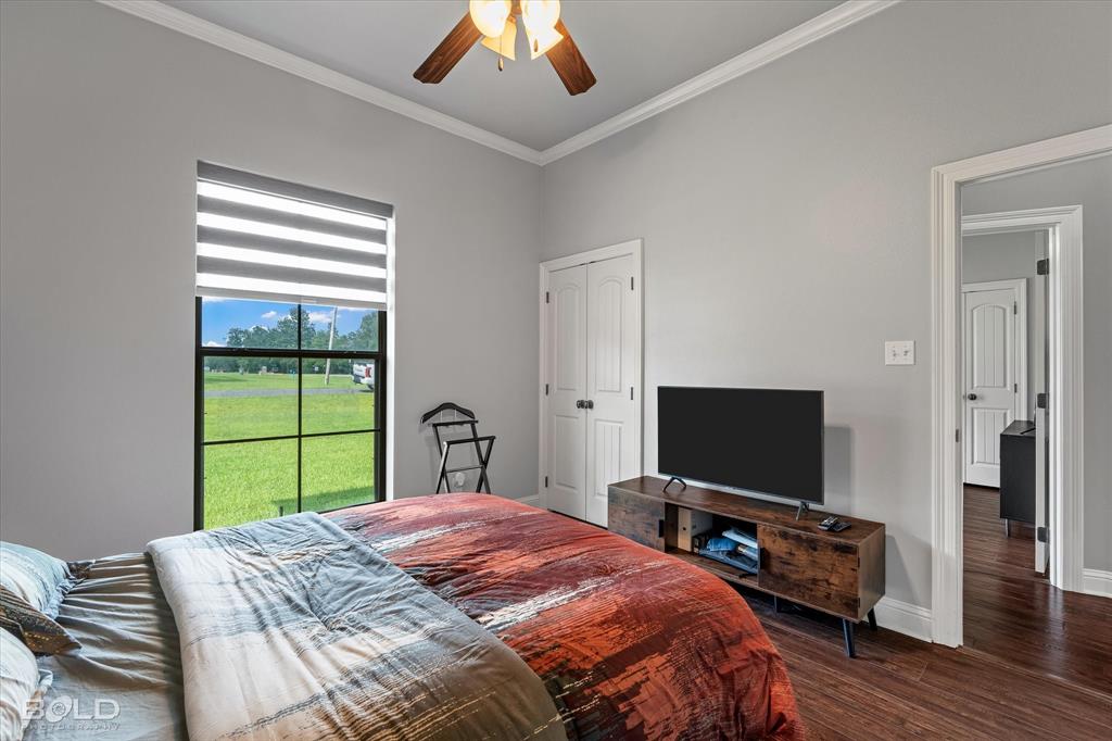2220 Forest Hills Boulevard Haughton, LA 71037 - Photo 32 of 40 Spacious room featuring a large window with horizontal blinds, wood-finish flooring, crown molding, and a ceiling fan