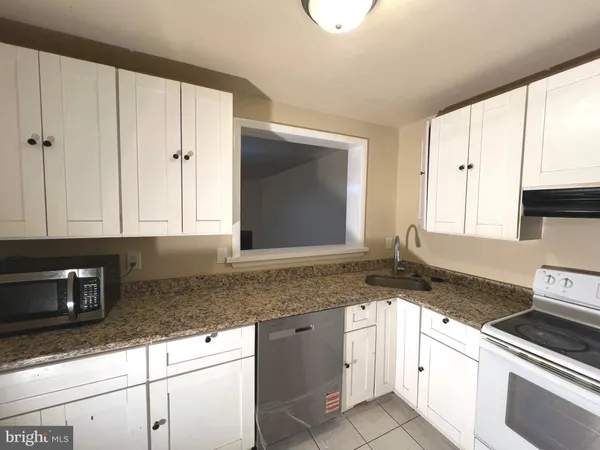a kitchen with granite countertop a sink and cabinets