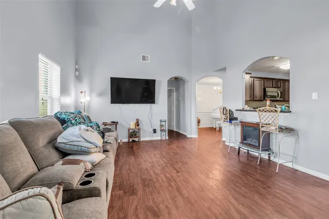 a living room with furniture a flat screen tv and wooden floor