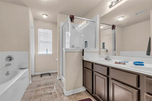 a bathroom with a sink double vanity mirror and a bathtub