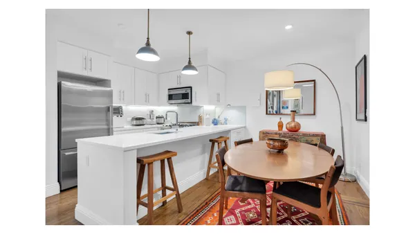 a kitchen with stainless steel appliances a sink a table and chairs