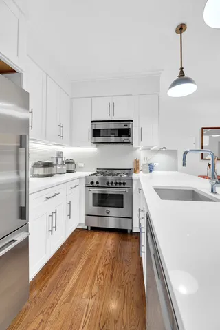 a kitchen with a table chairs sink and cabinets