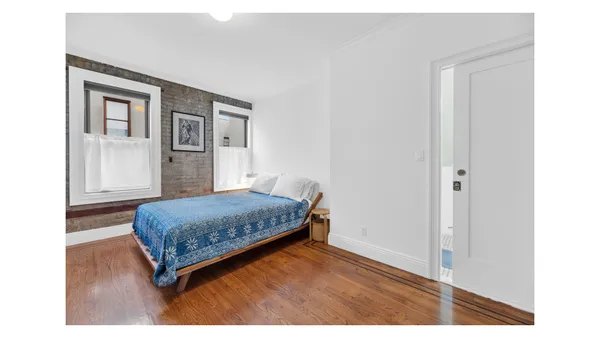 a bedroom with a bed and a painting on the wall