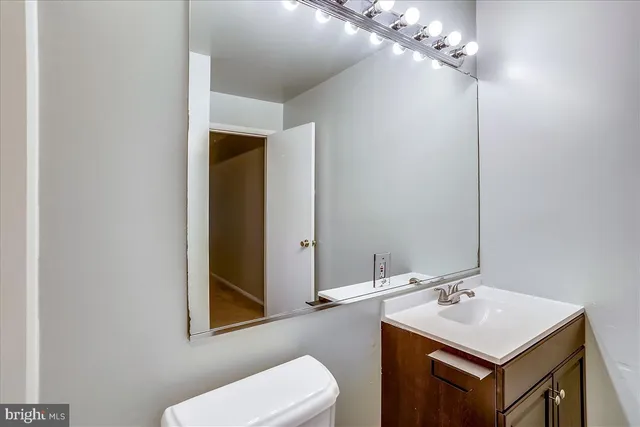 a bathroom with a sink vanity mirror and toilet