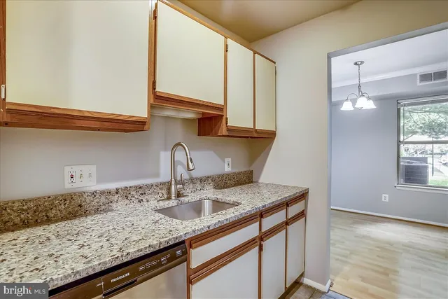 a kitchen with granite countertop a sink and cabinets