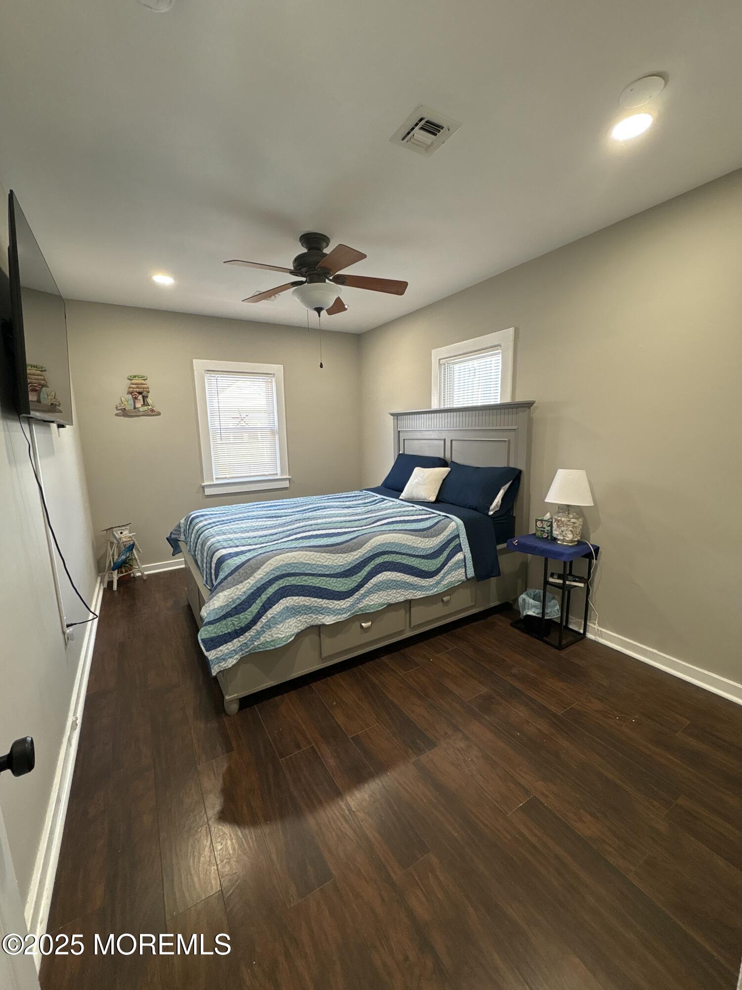 215 Webster Avenue, Unit 2 Seaside Heights, NJ 08751 - Photo 7 of 10 a bedroom with a bed and a chandelier