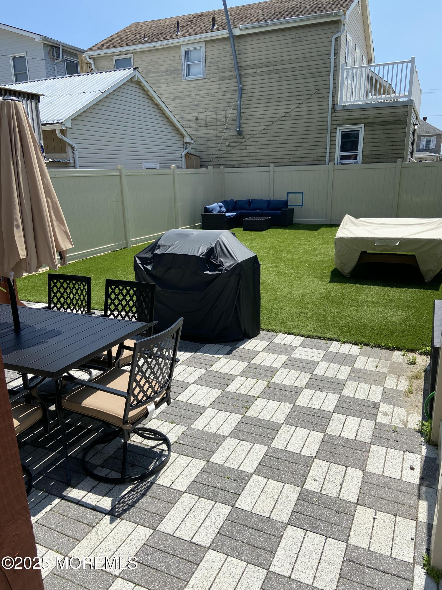 215 Webster Avenue, Unit 2 Seaside Heights, NJ 08751 - Photo 10 of 10 a backyard of a house with table and chairs