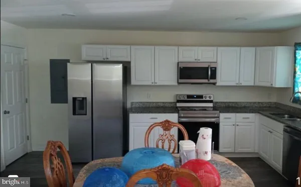 a kitchen with stainless steel appliances granite countertop a refrigerator stove top oven a sink and dishwasher