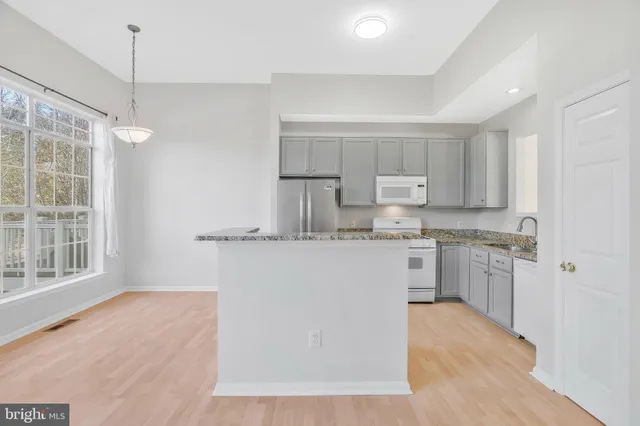 a kitchen with a refrigerator a sink and cabinets