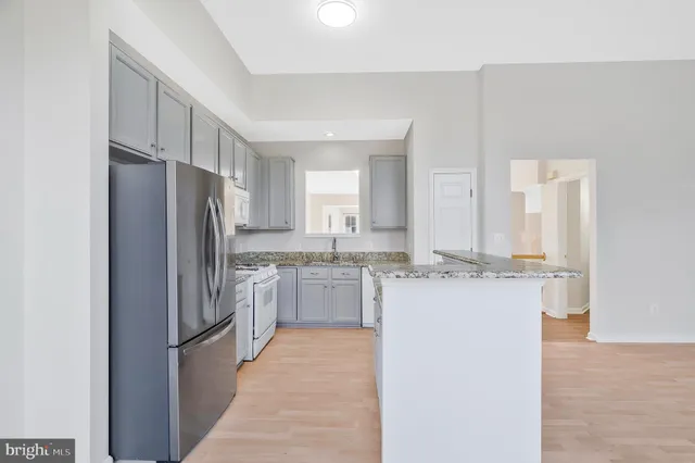 a kitchen with kitchen island a sink refrigerator and cabinets