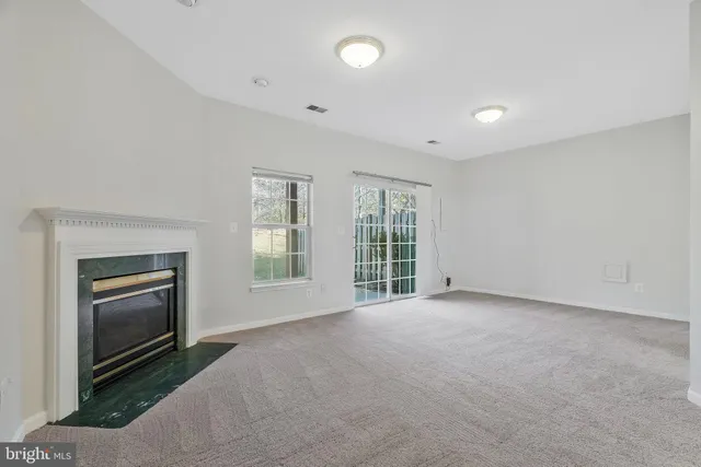a view of an empty room with a fireplace and a window