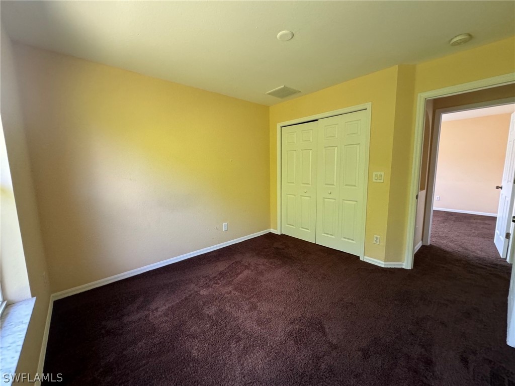 1841 Landale Loop Lehigh Acres, FL 33972 - Photo 14 of 21 an empty room with wooden floor and windows