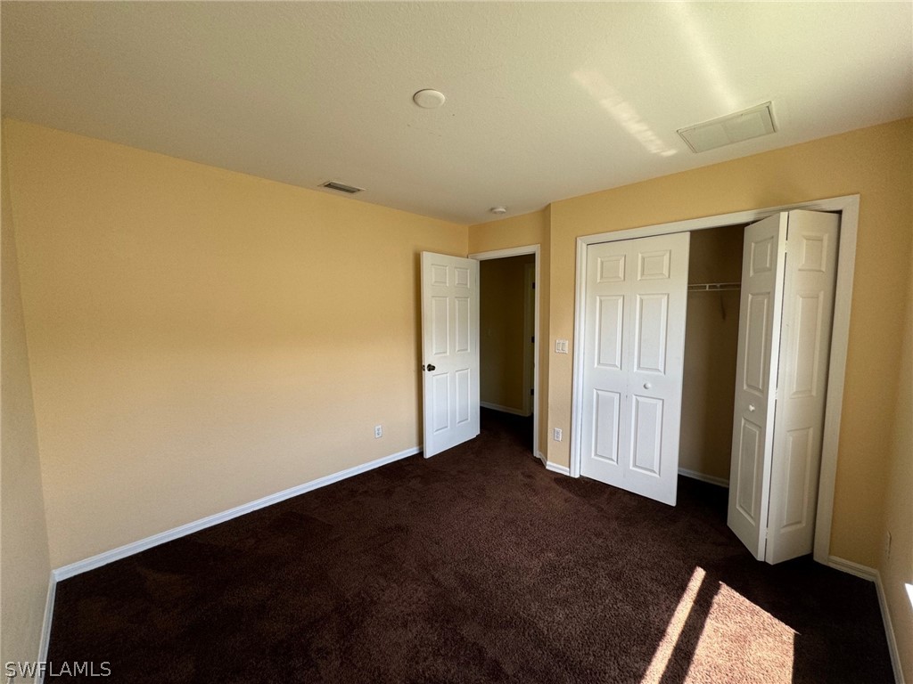 1841 Landale Loop Lehigh Acres, FL 33972 - Photo 16 of 21 an empty room with wooden floor and closet