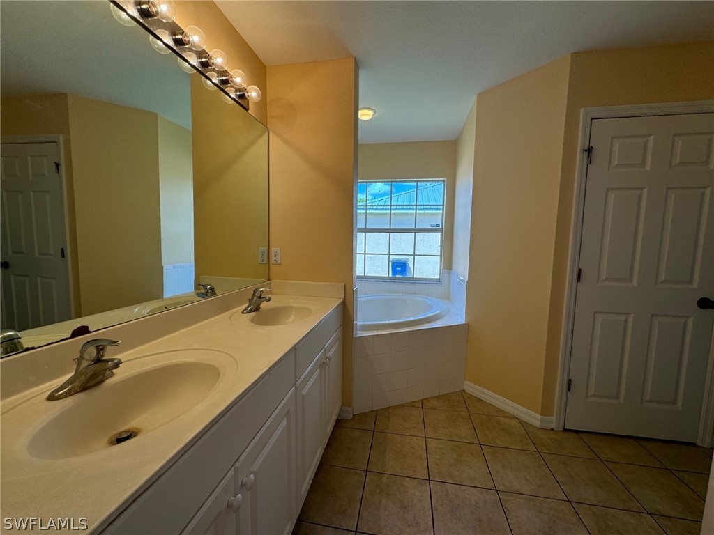 1841 Landale Loop Lehigh Acres, FL 33972 - Photo 9 of 21 a bathroom with a tub sink and mirror