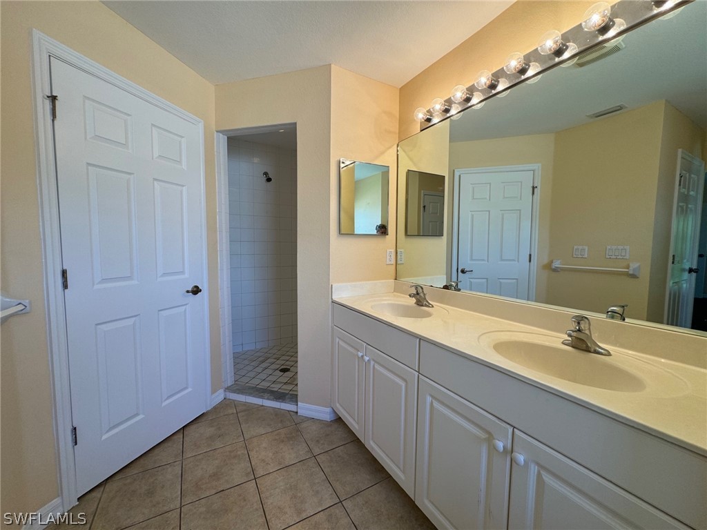 1841 Landale Loop Lehigh Acres, FL 33972 - Photo 10 of 21 a bathroom with a double vanity sink and a mirror