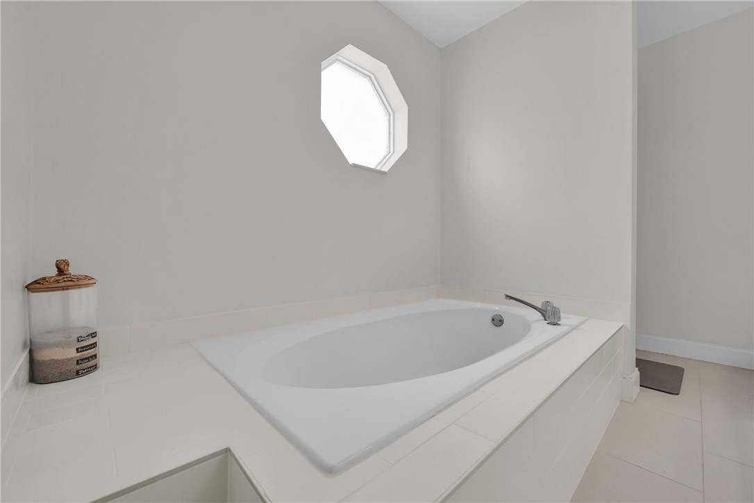 1950 Southwest Logwood Road Port St. Lucie, FL 34953 - Photo 16 of 32 a white bath tub sitting next to a white sink