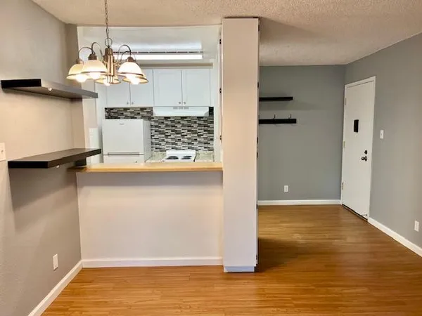 a view of a kitchen with wooden floor and chandelier