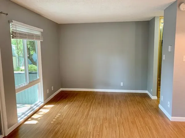 a view of a room with wooden floor and a window