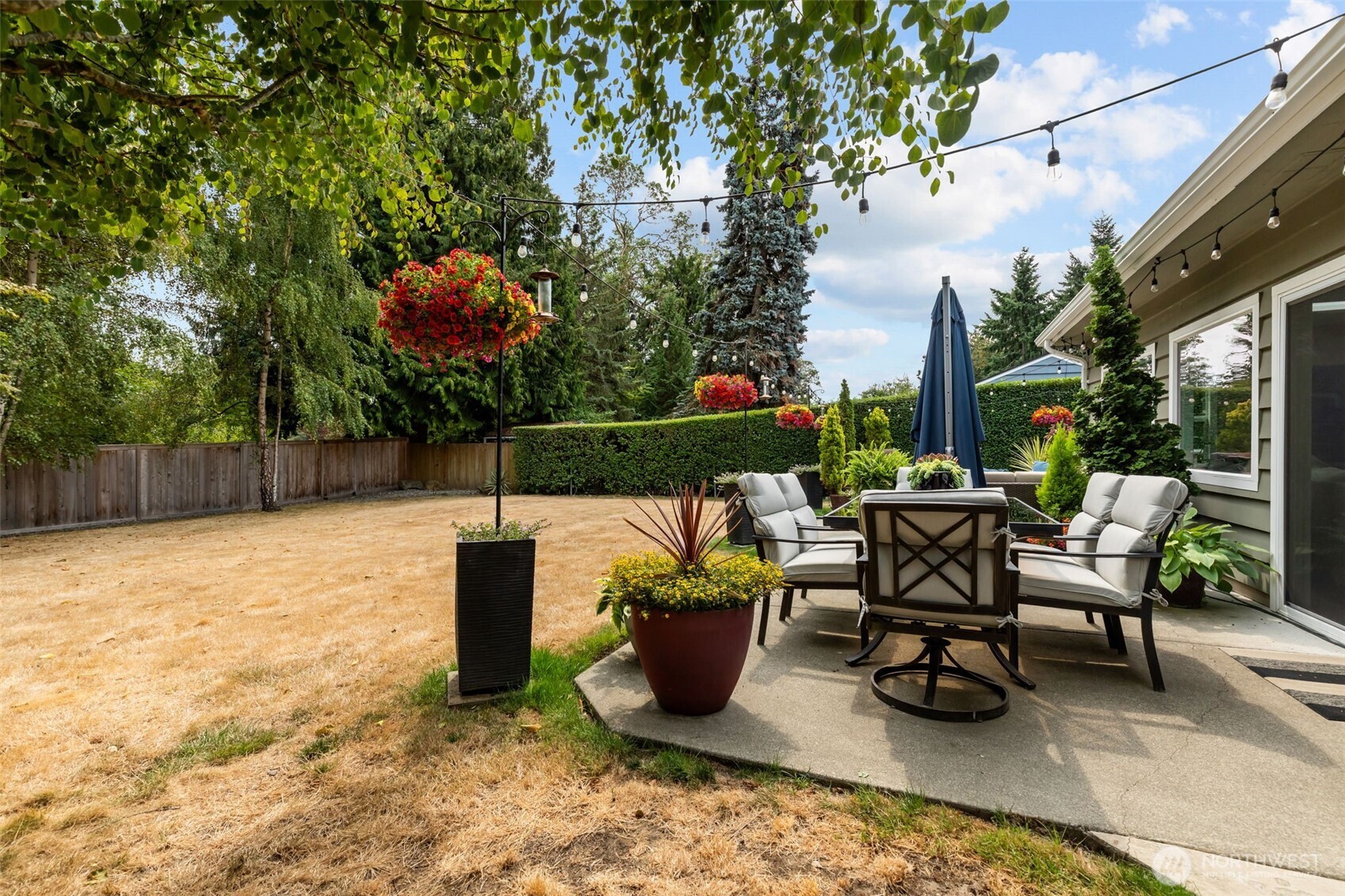 11462 35th Avenue Southwest Seattle, WA 98146 - Photo 18 of 26 a view of a patio with table and chairs potted plants and a large tree