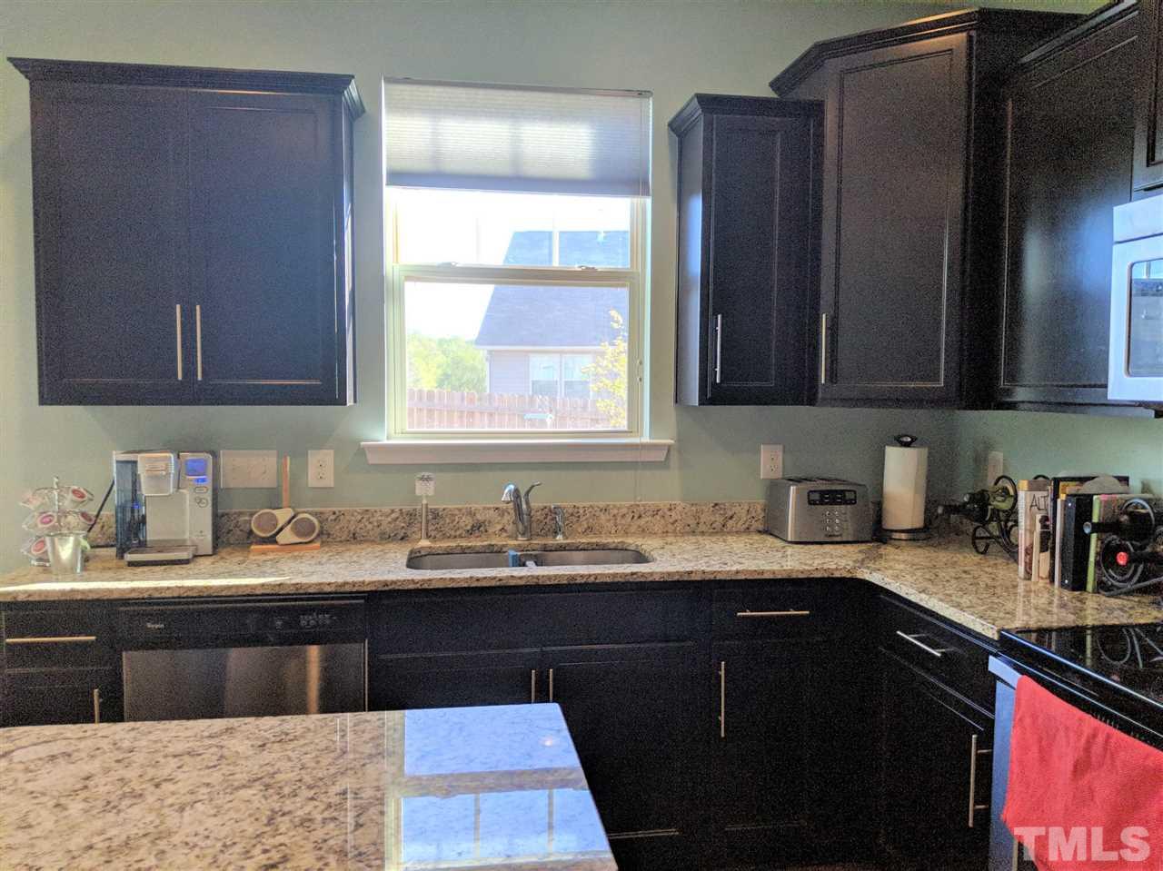 2716 Communion Court Raleigh, NC 27610 - Photo 17 of 17 a kitchen with a sink a window and cabinets
