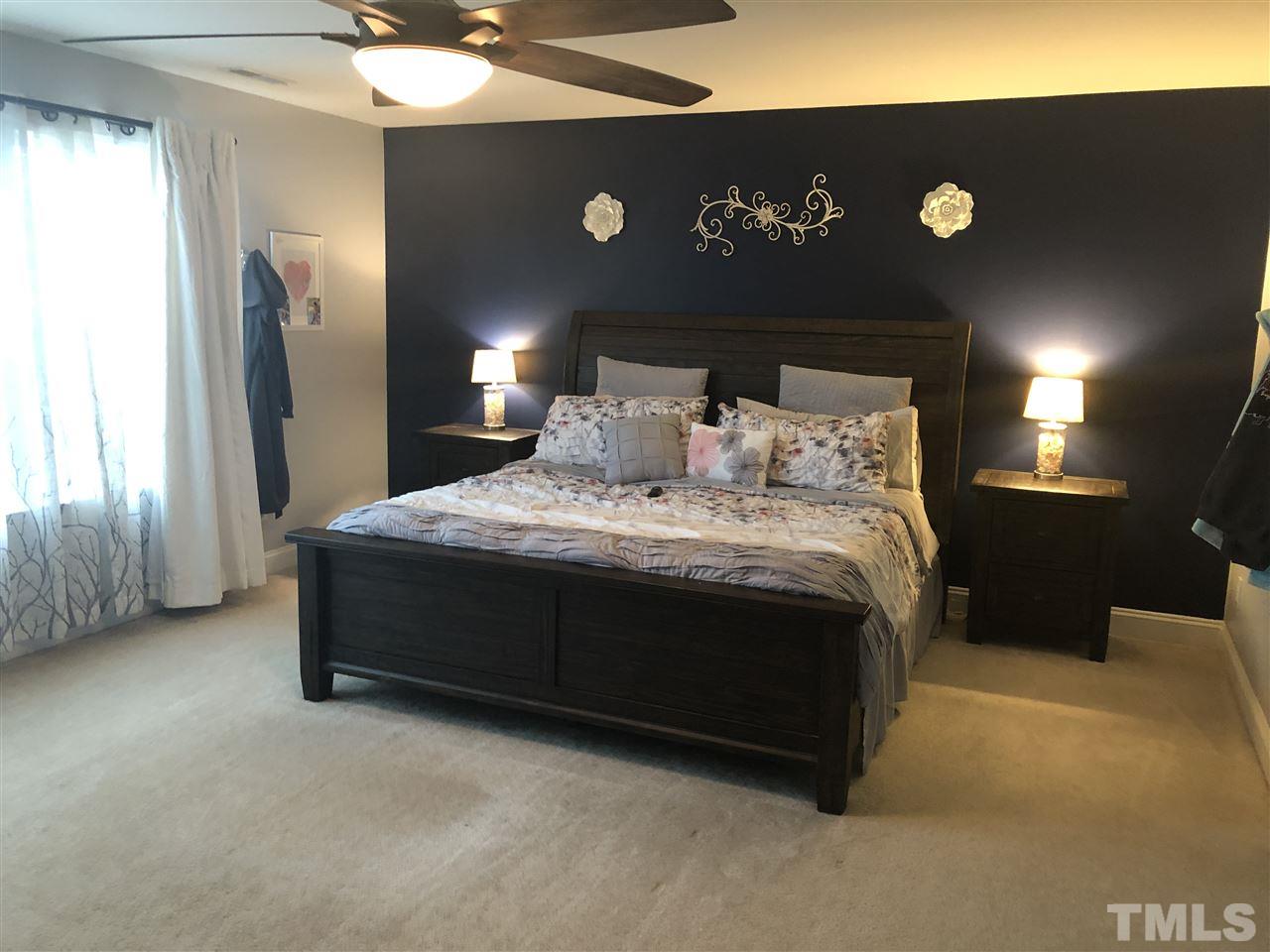 2716 Communion Court Raleigh, NC 27610 - Photo 3 of 17 a large bed sitting in a room next to a lamp