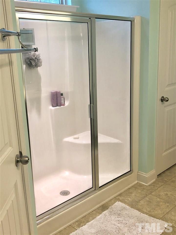 2716 Communion Court Raleigh, NC 27610 - Photo 8 of 17 a bathroom with a glass shower door