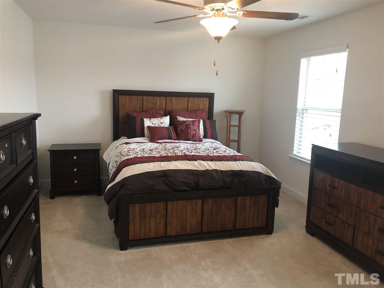 2716 Communion Court Raleigh, NC 27610 - Photo 10 of 17 a bedroom with a bed and a fireplace