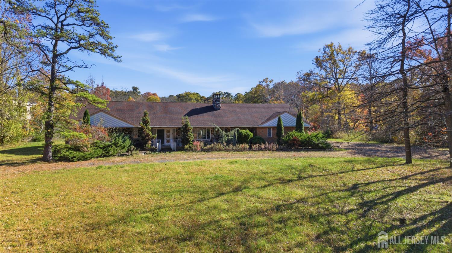 a view of a large house with a big yard and large trees