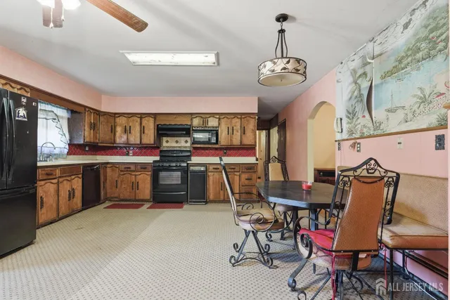 a dining room with stainless steel appliances kitchen island granite countertop a table chairs and a view of living room