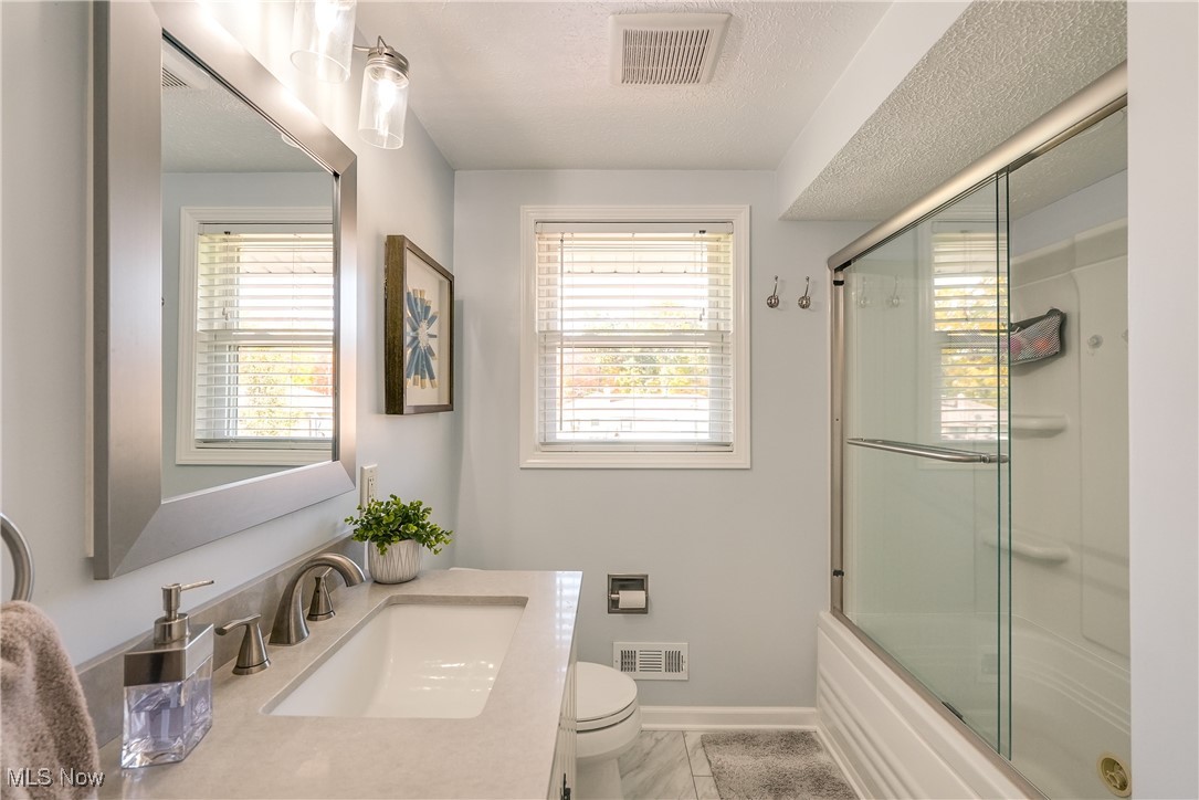 8296 Wright Road Broadview Heights, OH 44147 - Photo 19 of 45 Full bathroom with vanity, enclosed tub / shower combo, a textured ceiling, and toilet