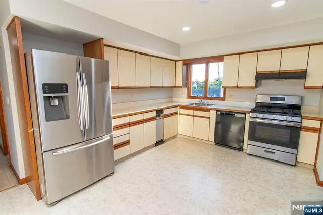 a kitchen with white cabinets and stainless steel appliances
