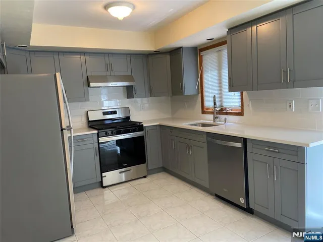 a kitchen with a sink a refrigerator and cabinets