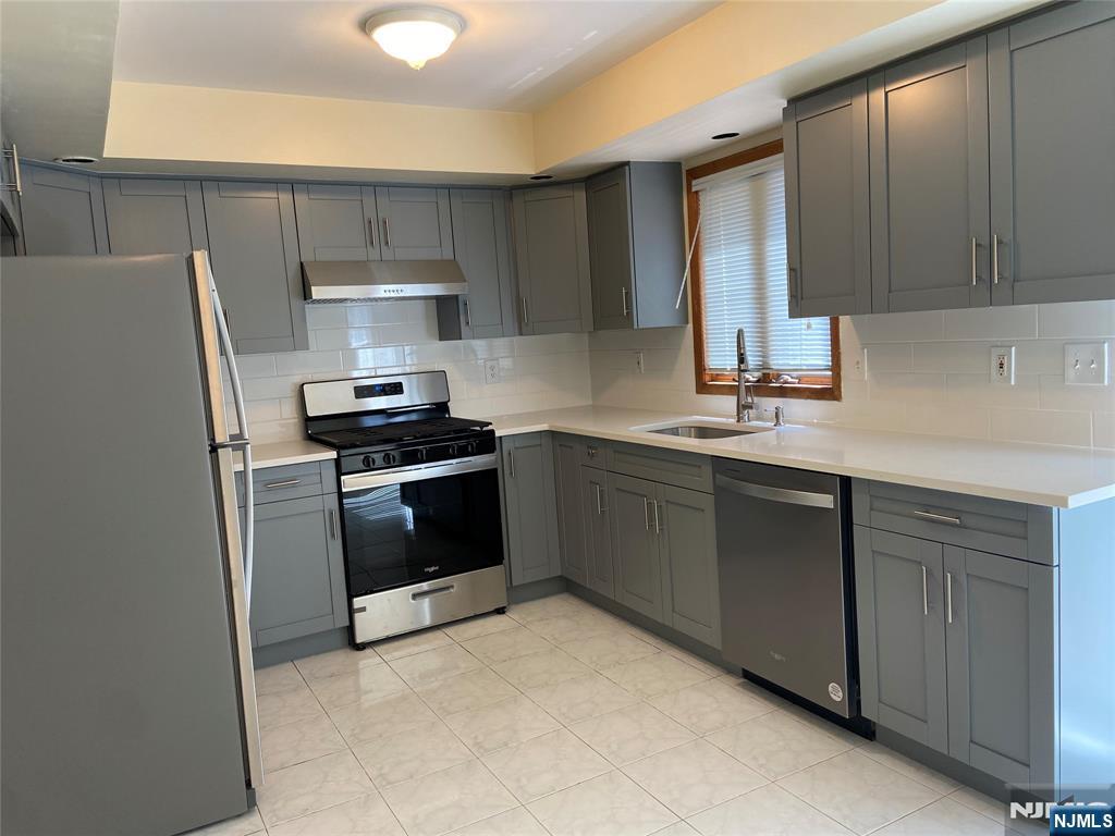 2416 Hammett Avenue, Unit A Fort Lee, NJ 07024 - Photo 3 of 8 a kitchen with a sink a refrigerator and cabinets