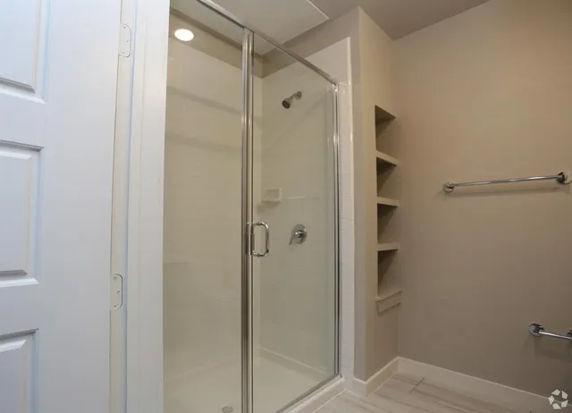 a bathroom with a shower and a glass door