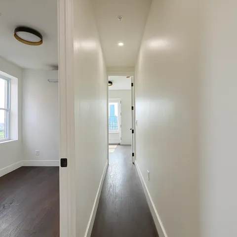 a view of a hallway with wooden floor and closet