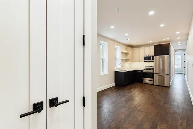 a view of kitchen with refrigerator sink and cabinets