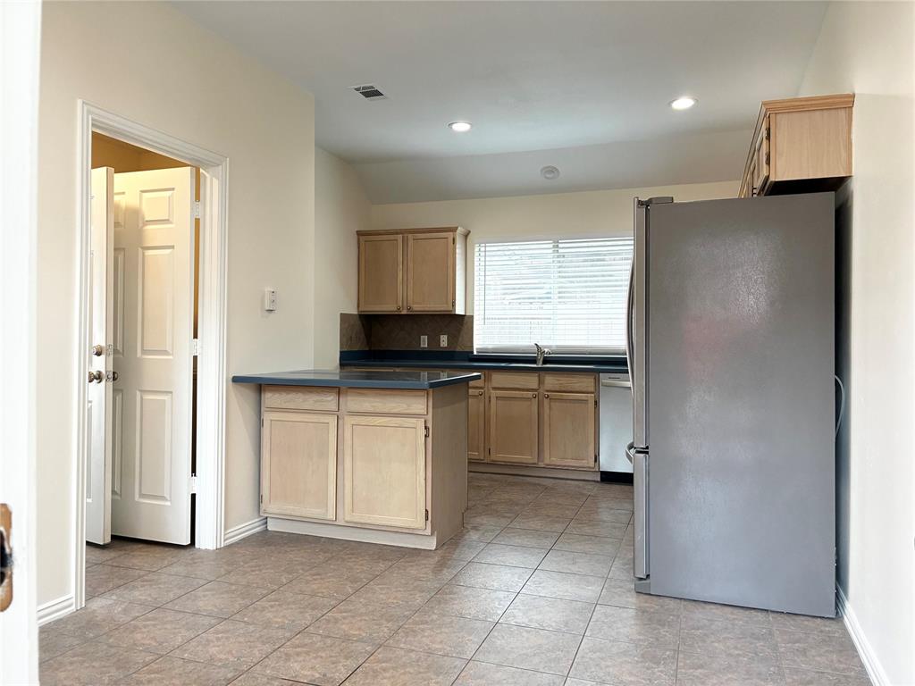 7936 Tournament Road Frisco, TX 75035 - Photo 13 of 28 a kitchen with a refrigerator and white cabinets