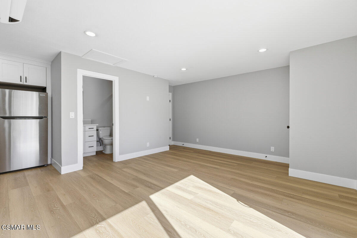1069 Donner Avenue, Unit B Simi Valley, CA 93065 - Photo 4 of 7 a view of an empty room with wooden floor and a kitchen