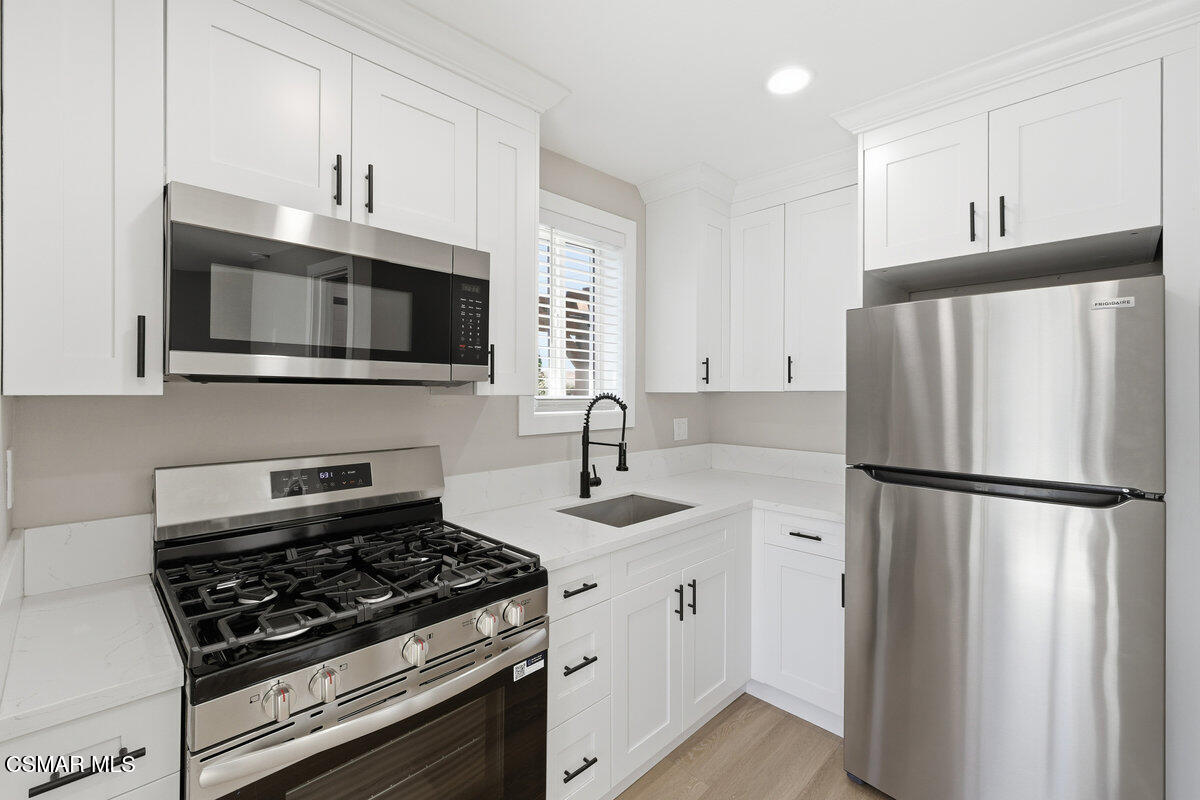 1069 Donner Avenue, Unit B Simi Valley, CA 93065 - Photo 5 of 7 a kitchen with refrigerator a microwave a sink and cabinets