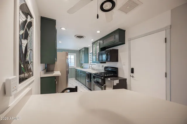 a large kitchen with a large counter top appliances and cabinets