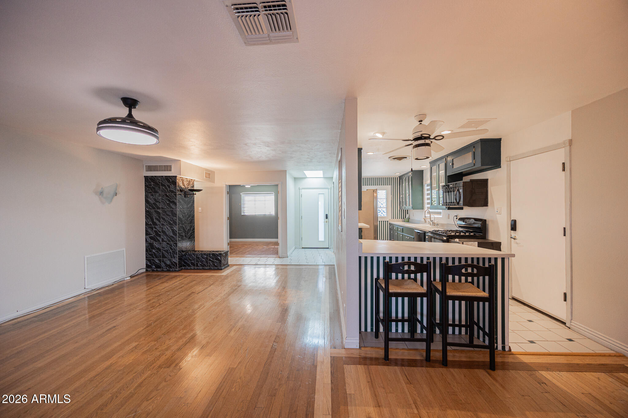 3137 North 4th Avenue Phoenix, AZ 85013 - Photo 8 of 36 a open kitchen with stainless steel appliances a refrigerator and a wooden floor