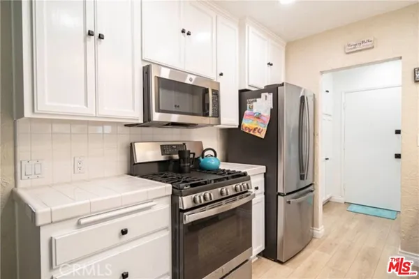 a kitchen with stainless steel appliances granite countertop a stove and a refrigerator