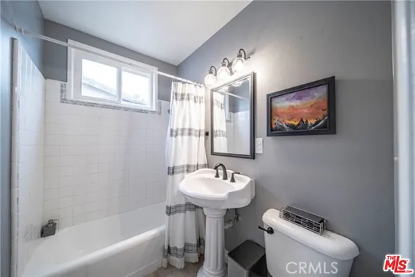 a bathroom with a toilet sink a shower and a mirror