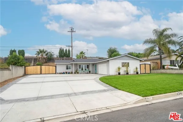 a front view of a house with a yard and potted plants