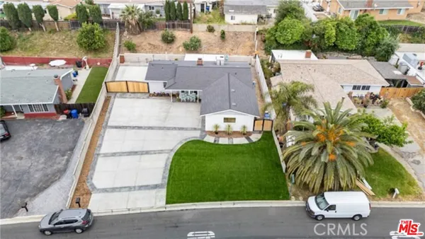 an aerial view of a house with garden space and street view