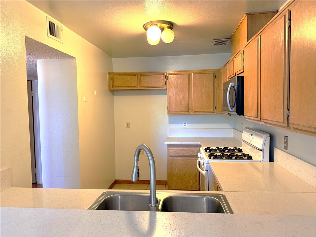 8939 Gallatin Road, Unit 123 Pico Rivera, CA 90660 - Photo 8 of 21 a kitchen with a refrigerator and a sink