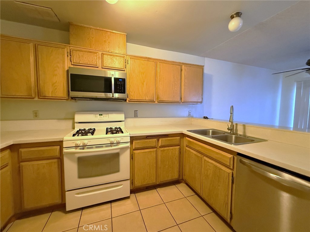 8939 Gallatin Road, Unit 123 Pico Rivera, CA 90660 - Photo 9 of 21 a kitchen with a stove sink and microwave